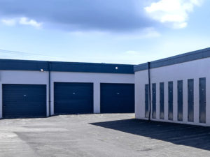 Outdoor storage units with blue roll up doors at Pacific Rim Storage Courtenay, showing secure drive up access and multiple unit sizes.